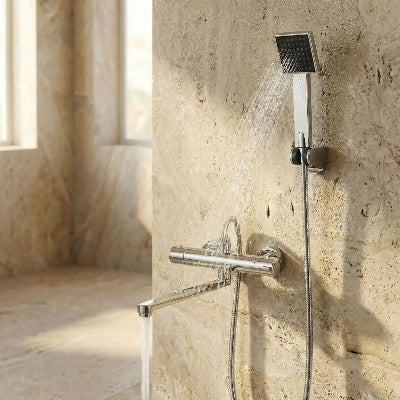mitigeur douche argent chromé sur mur en pierre beige