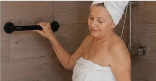 arre d'appui WC noire fixée au mur pour la sécuriser