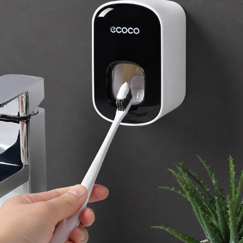 Distributeur de dentifrice automatique noir fixé sur un mur gris 