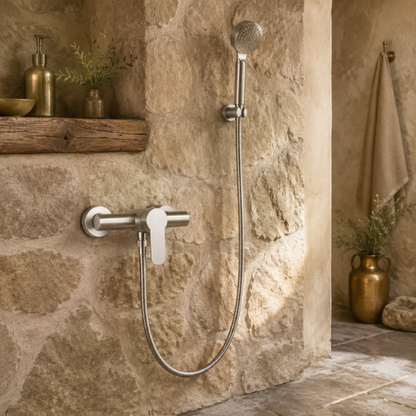 Mitigeur avec pommeau à main installé dans une douche rustique