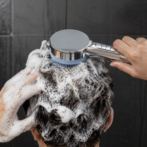 Pommeau de douche massant chromé utilisé sur des cheveux