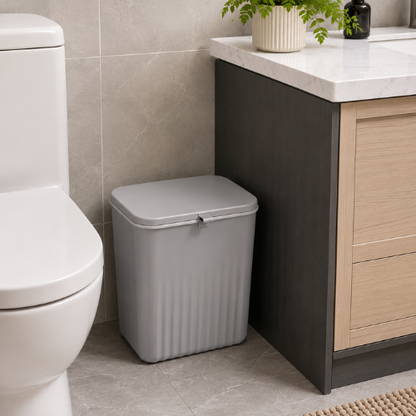 Poubelle de salle de bain grise posée au sol