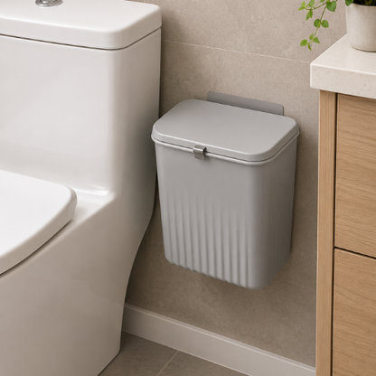 Poubelle murale grise fixée dans une salle de bain