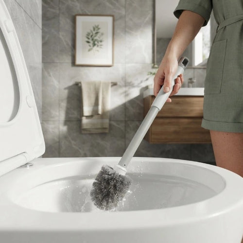Brosse WC à tête ronde noire utilisée pour nettoyer une cuvette