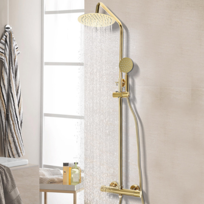 colonne-de-douche-doré-sur-un-mur-en-céramique-beige