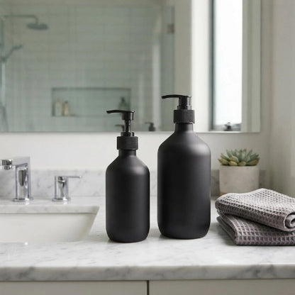 ​Deux distributeurs de savon noirs posés près d’un lavabo moderne
