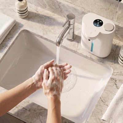 Distributeur de savon à détection infrarouge au-dessus d’un lavabo