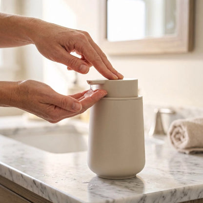 Distributeur de savon beige à pompe sur un lavabo