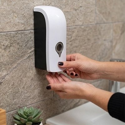 Distributeur de savon mural blanc et noir fixé au mur