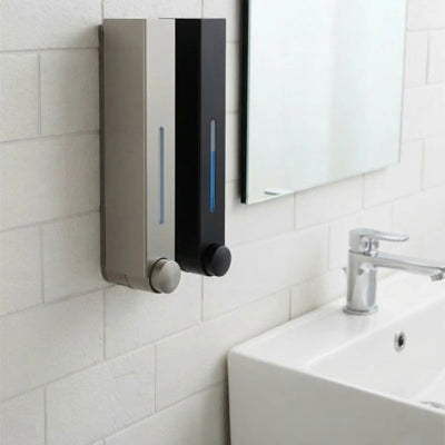 distributeur de savon mural noir et gris sur mur blanc