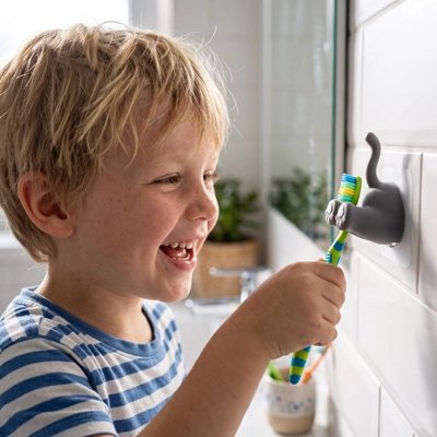 ​Enfant utilisant un porte-brosse à dents mural ludique