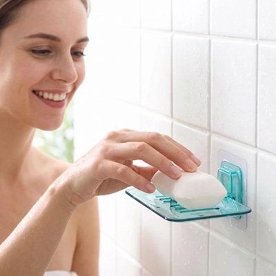 Femme déposant un savon dans un porte-savon mural transparent