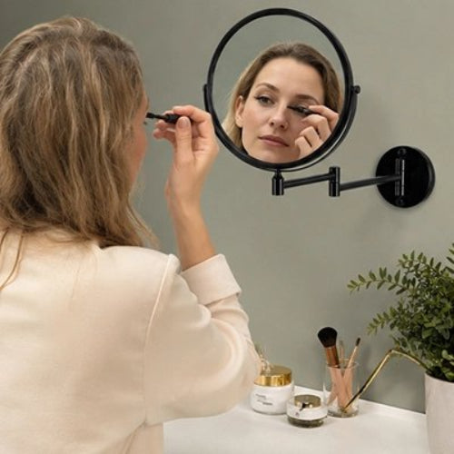 Femme se maquillant devant un miroir grossissant mural noir
