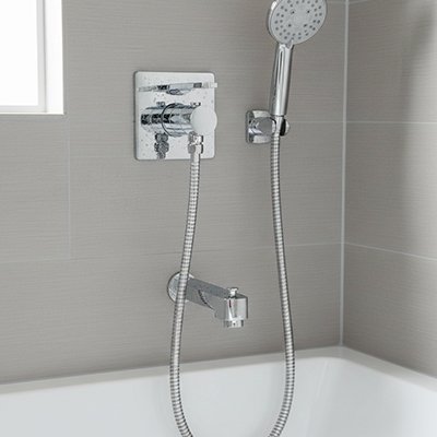 Flexible de douche chromé installé dans une douche moderne