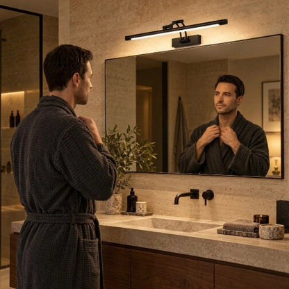 Homme devant un miroir rectangulaire éclairé par une applique murale LED