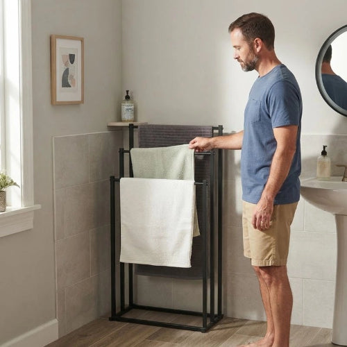 Homme près d’un portant à serviettes sur pied noir