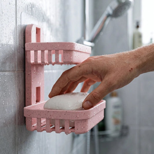 Main prenant un savon dans un porte-savon mural rose