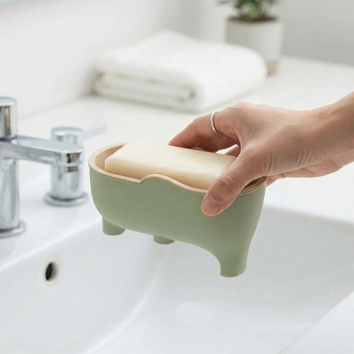 Main prenant un savon dans un porte-savon vert