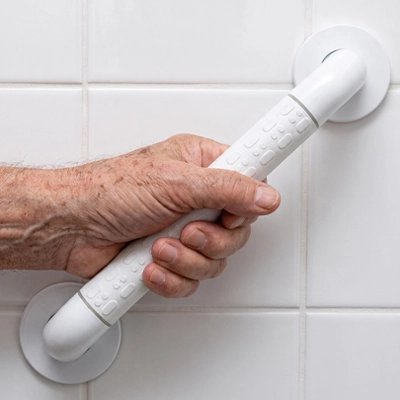 Main saisissant une barre d’appui blanche antidérapante pour salle de bain