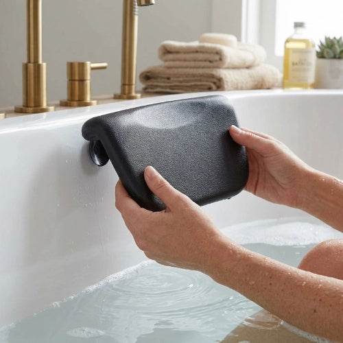 Mains installant un coussin pour baignoire noir sur la paroi