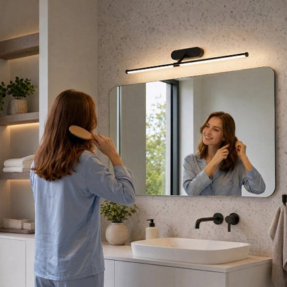 Miroir rectangulaire surmonté d’une applique murale LED noire