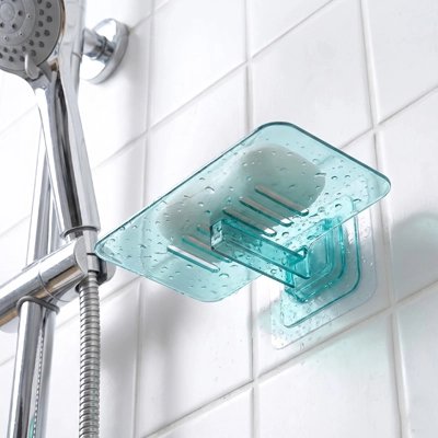 Porte-savon mural drainant installé près du robinet de douche