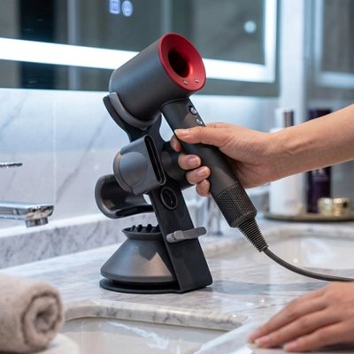 Porte sèche-cheveux noir vertical posé sur un lavabo