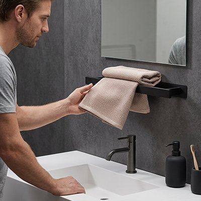 Porte-serviettes noir compact installé près d’un lavabo 