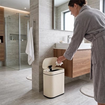 Poubelle étroite beige près d’un meuble de salle de bain