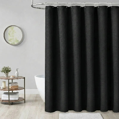 rideau de douche noir devant une baignoire autoportant