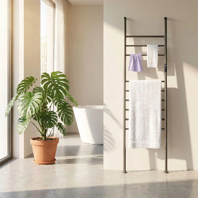 sèche serviettes gris canon contre un contre un mur beige