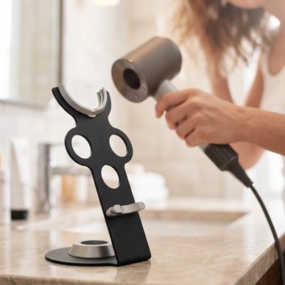 Sèche-cheveux noir rangé sur un support de comptoir élégant