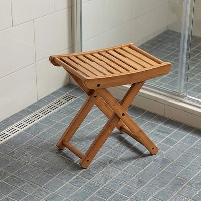 Tabouret de douche pliable en bois installé dans une douche 