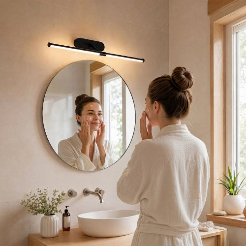 Un miroir rond éclairé par une applique murale noire
